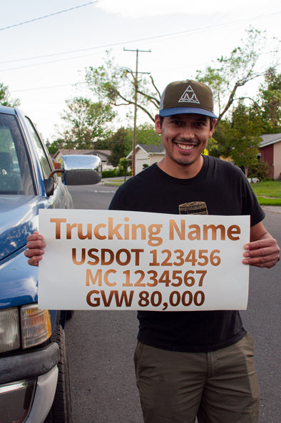 man holding trucking sign with usdot mc gvw lettering